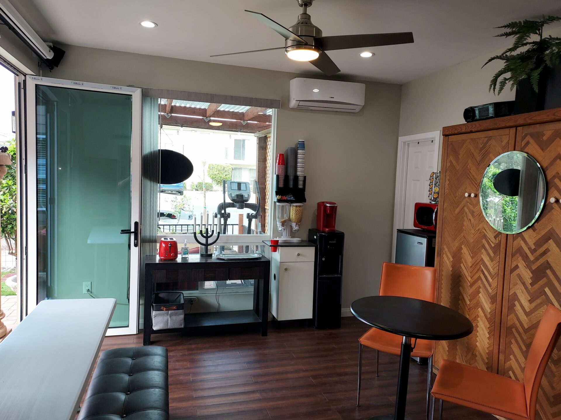 A room with a table, chairs and a coffee maker.