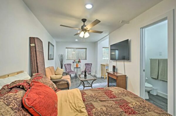 A bedroom with a bed, table and chair.