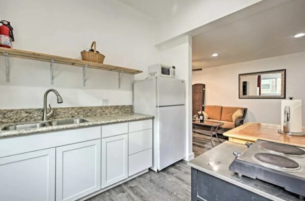 A kitchen with white cabinets and a sink.