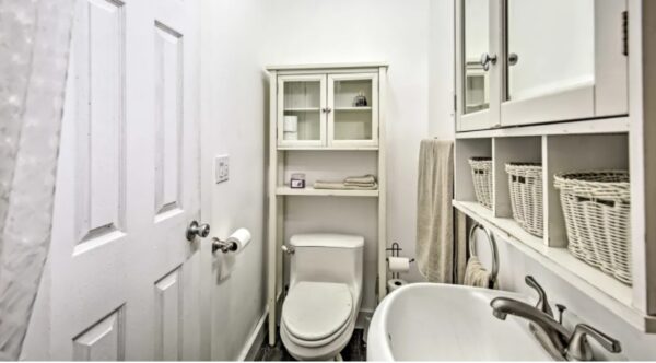 A bathroom with white walls and a toilet.