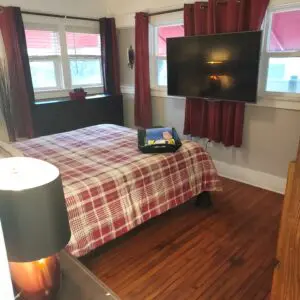 A bedroom with a bed, tv and desk.