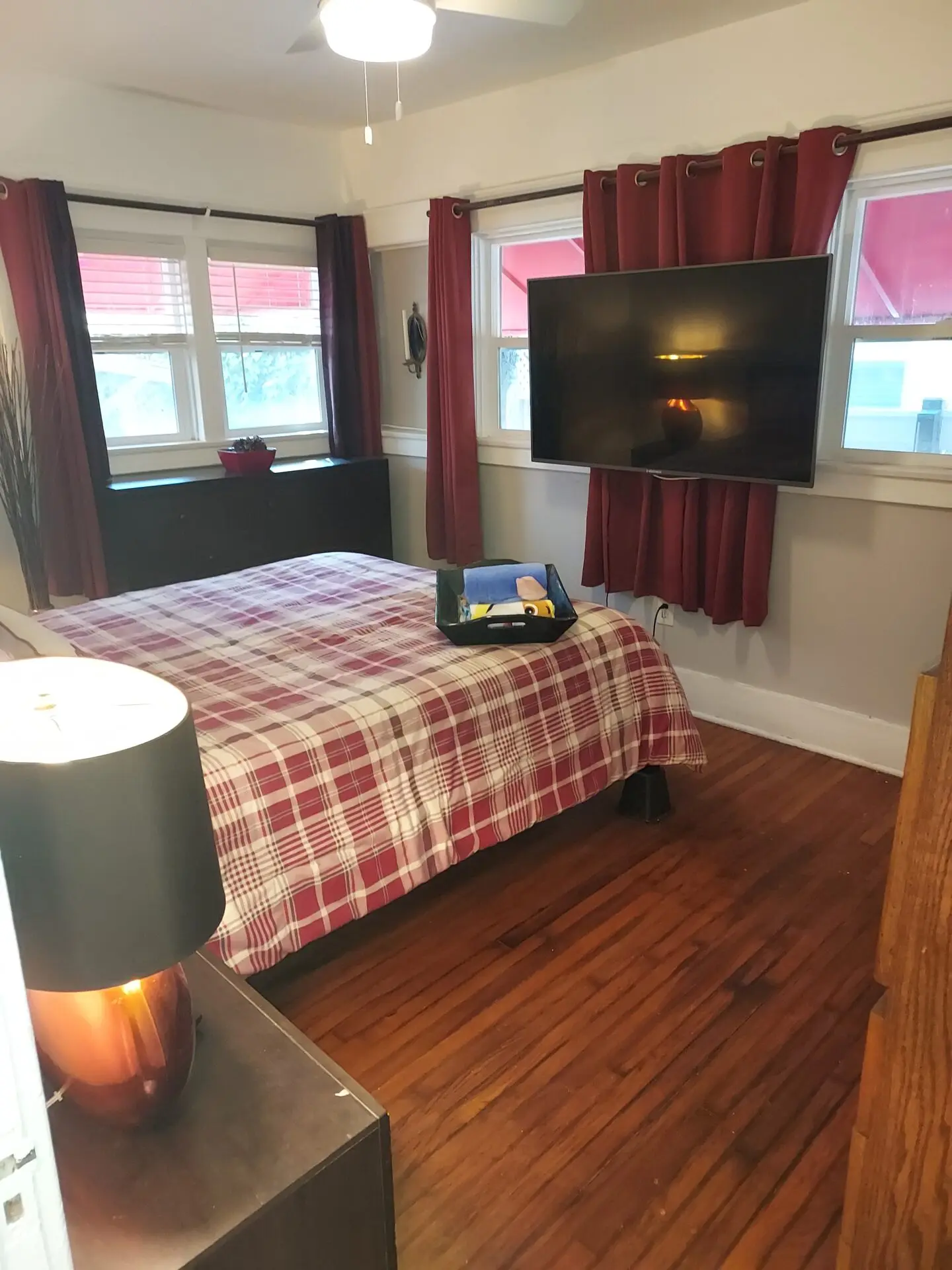 A bedroom with a bed, tv and desk.