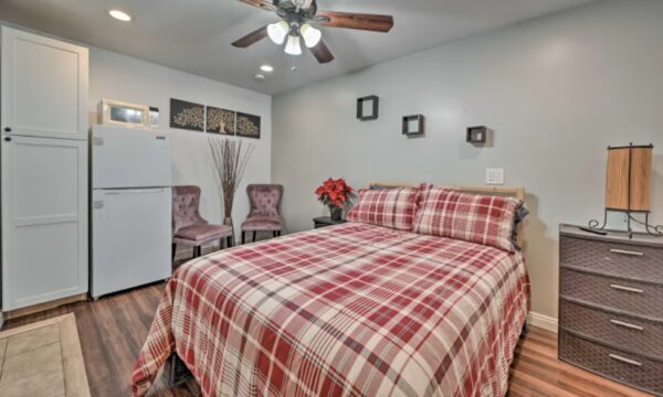 A bedroom with a bed, refrigerator and microwave.