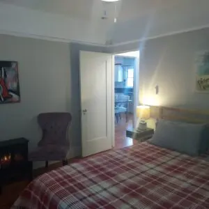 A bedroom with a bed, chair and fireplace.