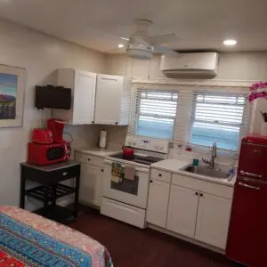 A kitchen with white cabinets and red appliances.