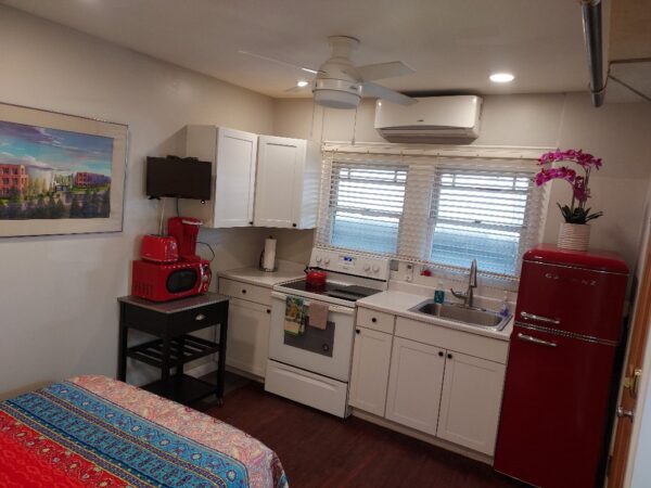 A kitchen with white cabinets and red appliances.