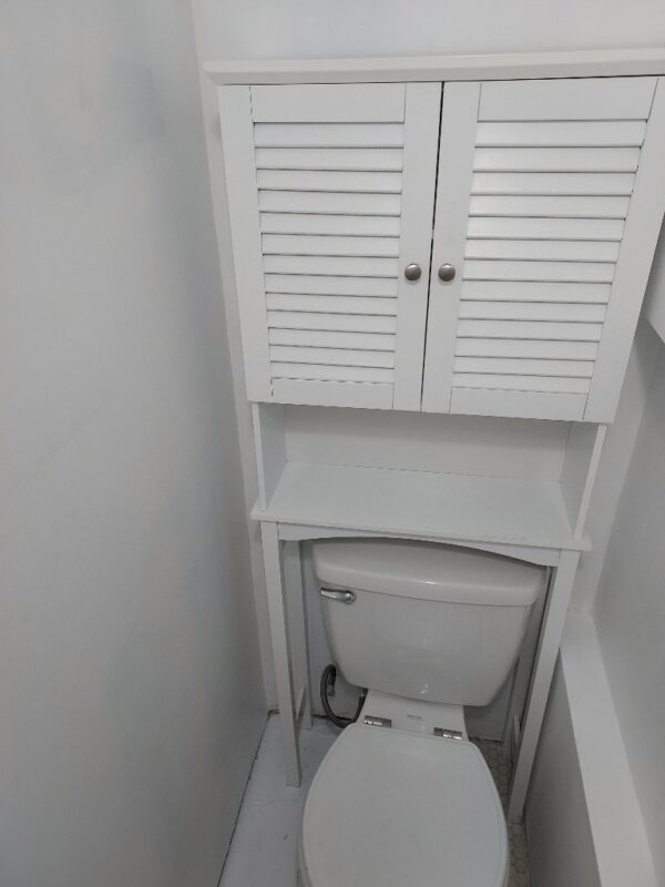 A white toilet sitting next to a bathroom sink.