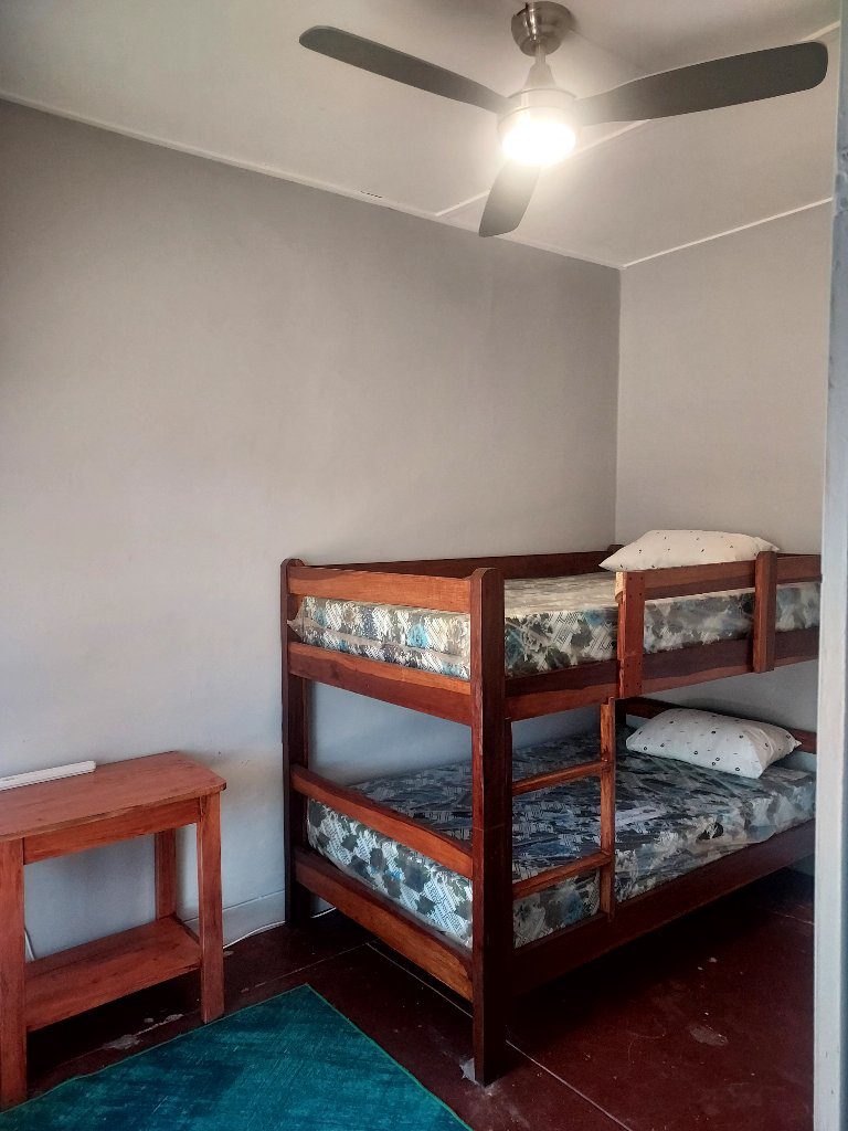 Simple room with bunk beds and a small wooden table.
